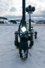 Motorized scooter with large wheels on a snowy landscape