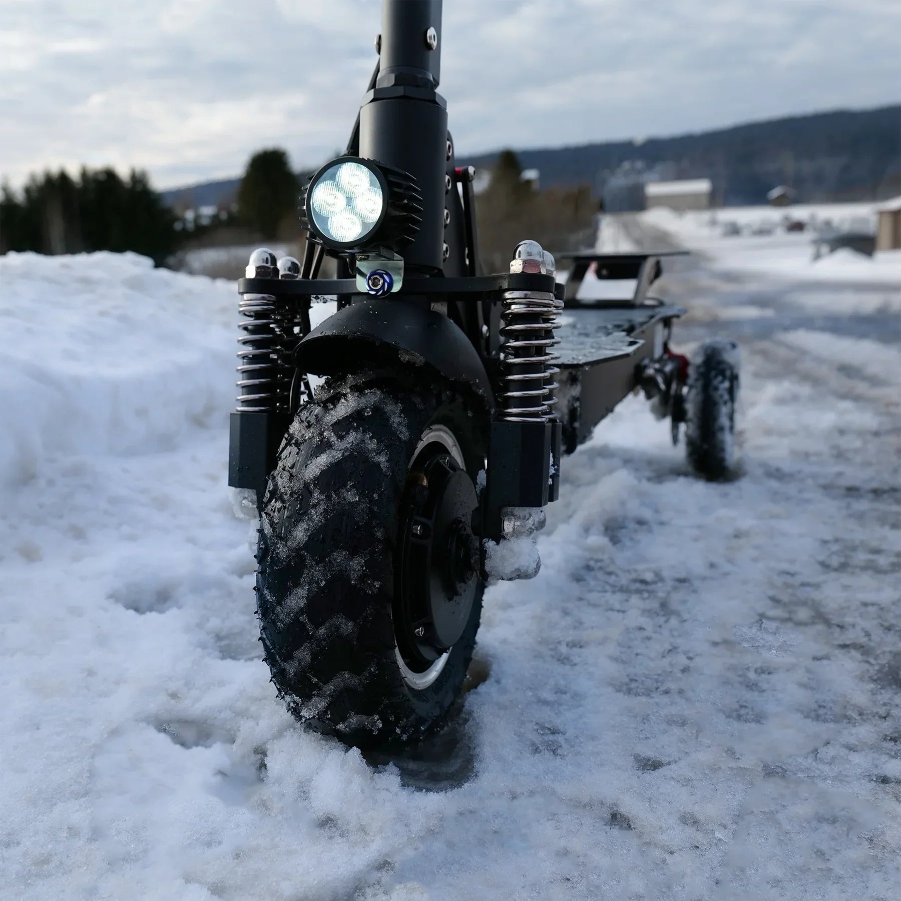 Electric scooter with large wheels on a snowy road