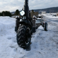 Electric scooter with large wheels on a snowy road