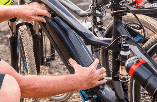 Detail view of electric bike battery being installed on a black e-bike frame