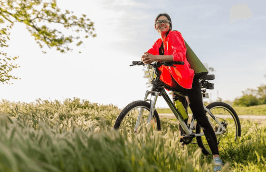 Woman riding electric bike outdoors in green field, Pogo Cycles e-bike lifestyle